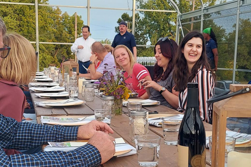 people sitting at a table eating barbecue and smiling